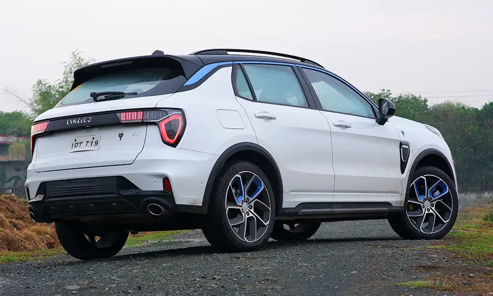 White Lynk & Co 01 SUV rear view on outdoor gravel road