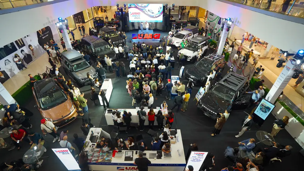 The UAAGI On the Move 2026 car exhibition showcasing a Lynk & Co connected SUV alongside other multi-brand vehicles and exclusive promos.
